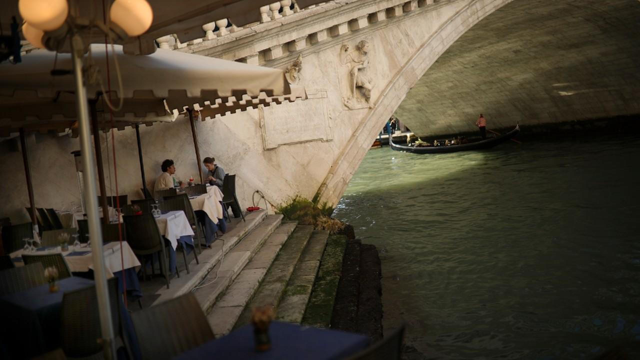 Una pareja de turistas en un restaurante desolado